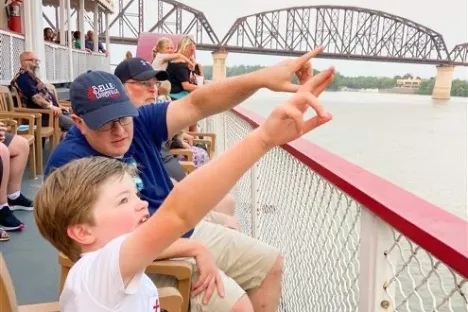 a group of people standing on top of a wooden fence