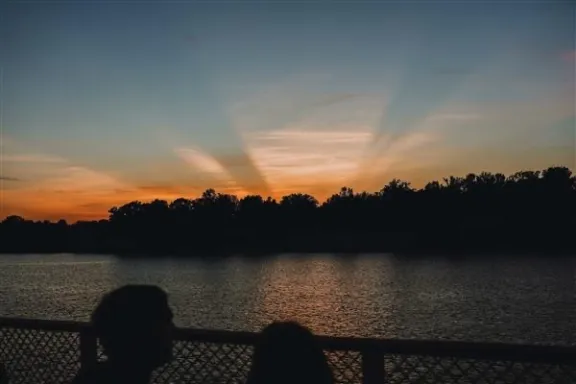 a man sitting in front of a body of water
