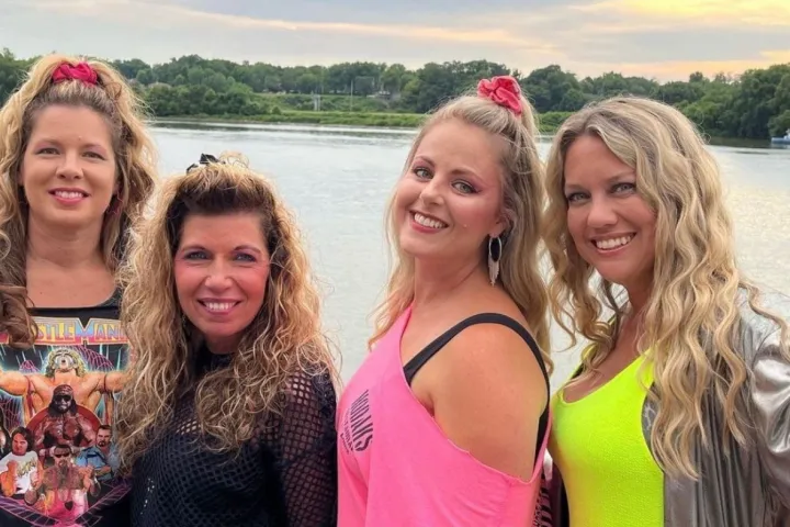 a group of people standing in a body of water posing for the camera