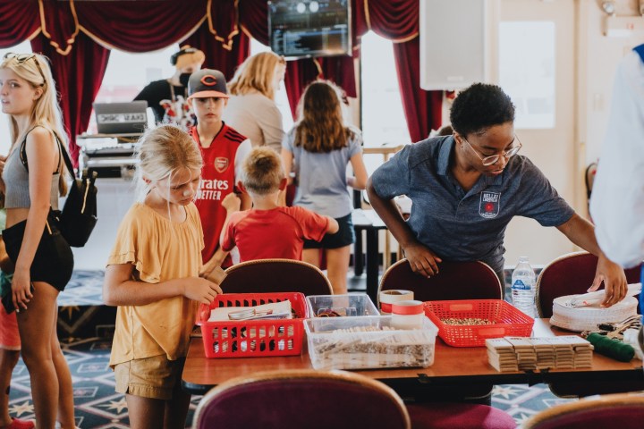 a group of people standing around a table