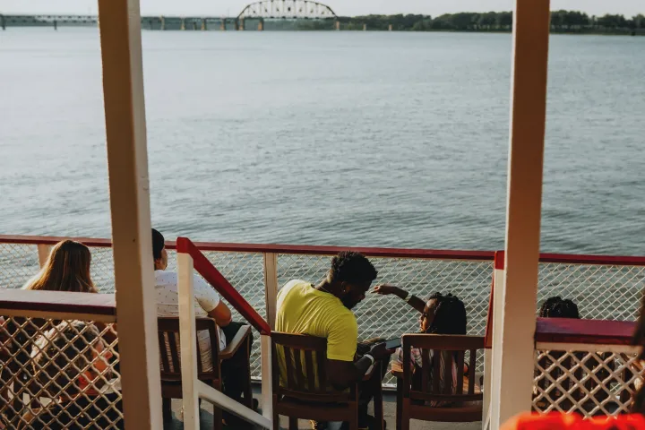 a group of people sitting in front of a body of water