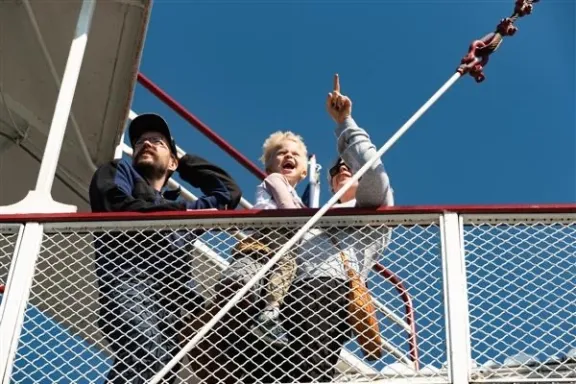a group of people standing next to a fence