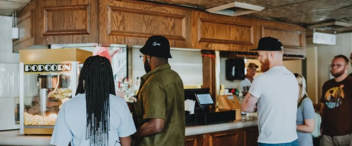 a group of people standing in a kitchen