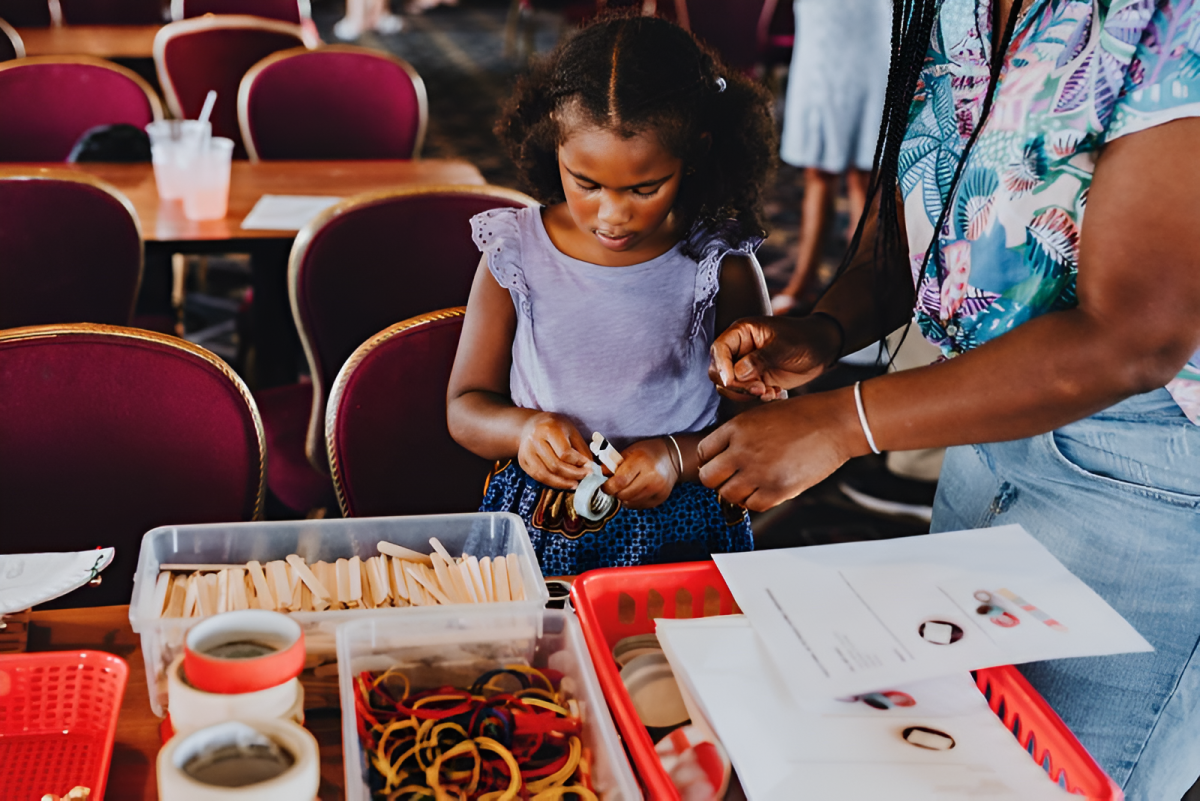 a little girl sitting at a table