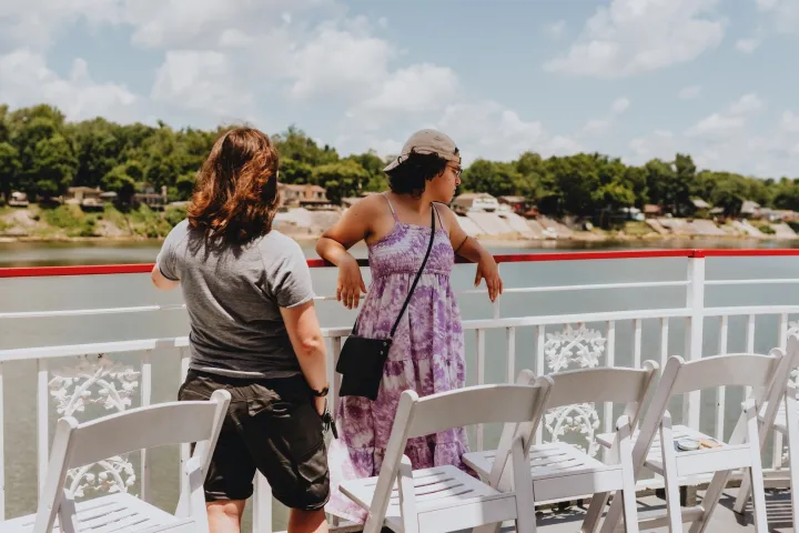 a woman sitting at a table in front of a fence